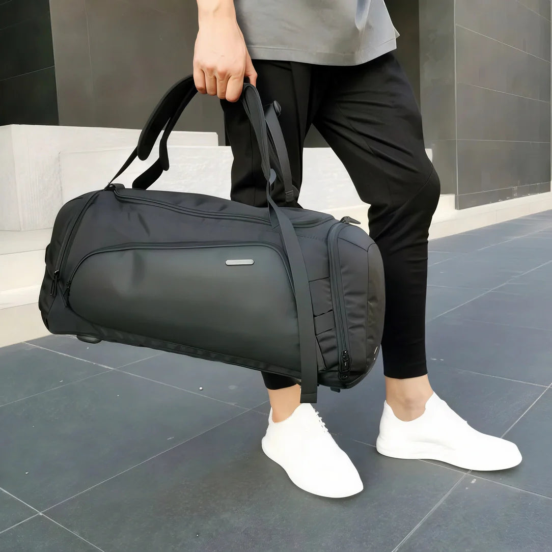 Sac de sport noir avec chaussures sport à semelle blanche et pantalon gris